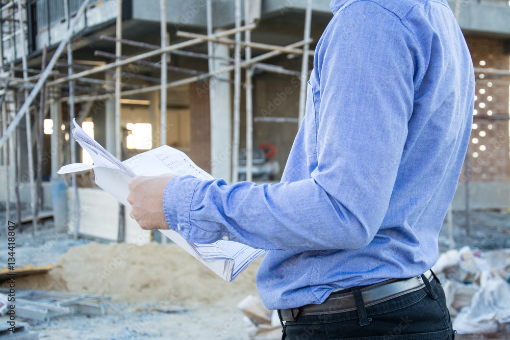 Engineer builder with blueprint at construction site Engineer builder with blueprint at construction site