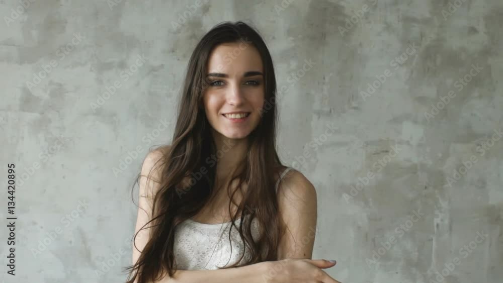 Slowmotion beautiful sexy girl pose into camera and smililng. Model tests in studio