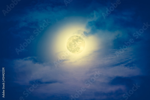 Nighttime sky with clouds and bright full moon with shiny.