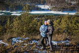 Young couple stand and hug on a rock in winter, Altay, Russia