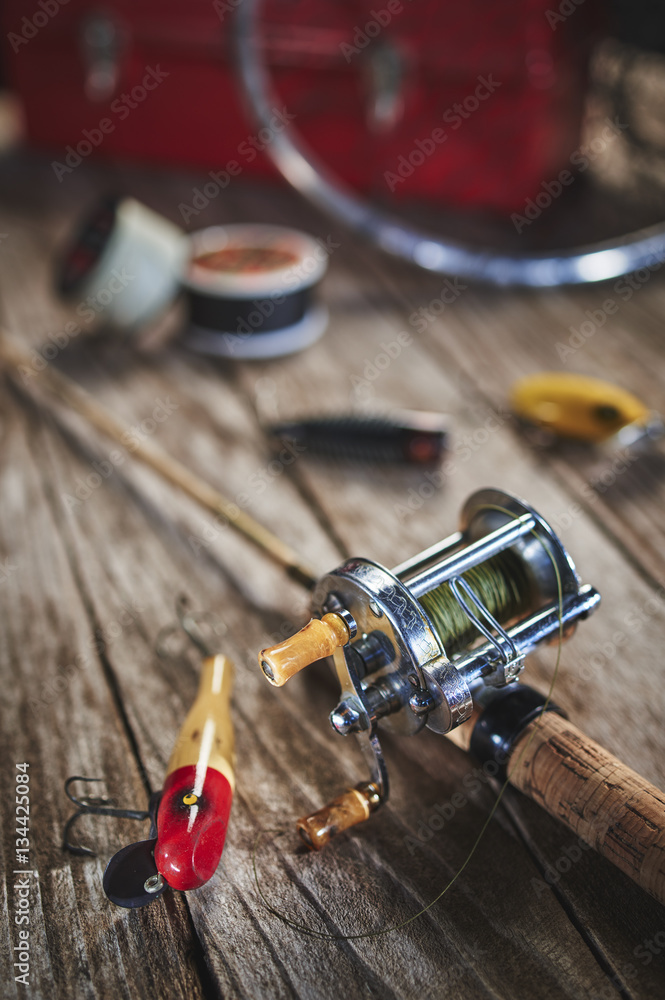 antique fishing lures, rod, and reel on a wood table Stock Photo
