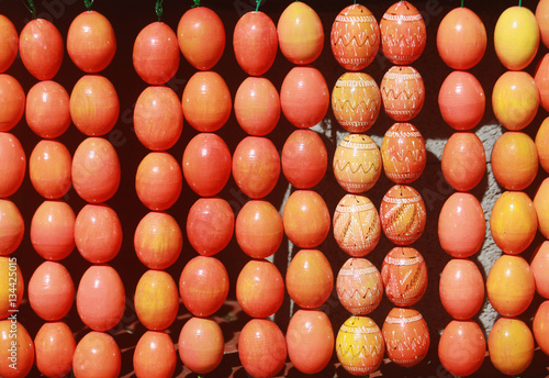 Easter background with painted eggs. Outdoor easter decoration with rows of bright painted eggs.