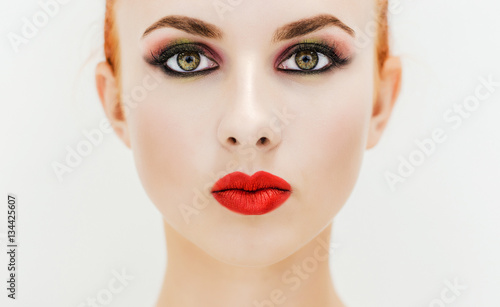 Close-up. Portrait of a woman with red lips on a light background