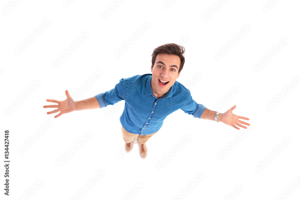 wide angle picture of an excited young casual man welcoming wide angle picture of an excited young casual man welcoming