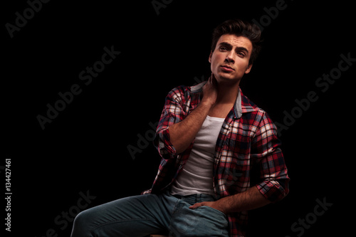 seated young casual man is looking up