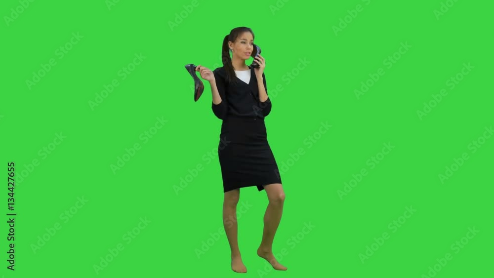 Young chatty woman using a shoe like a telephone on a Green Screen, Chroma Key Young chatty woman using a shoe like a telephone on a Green Screen, Chroma Key