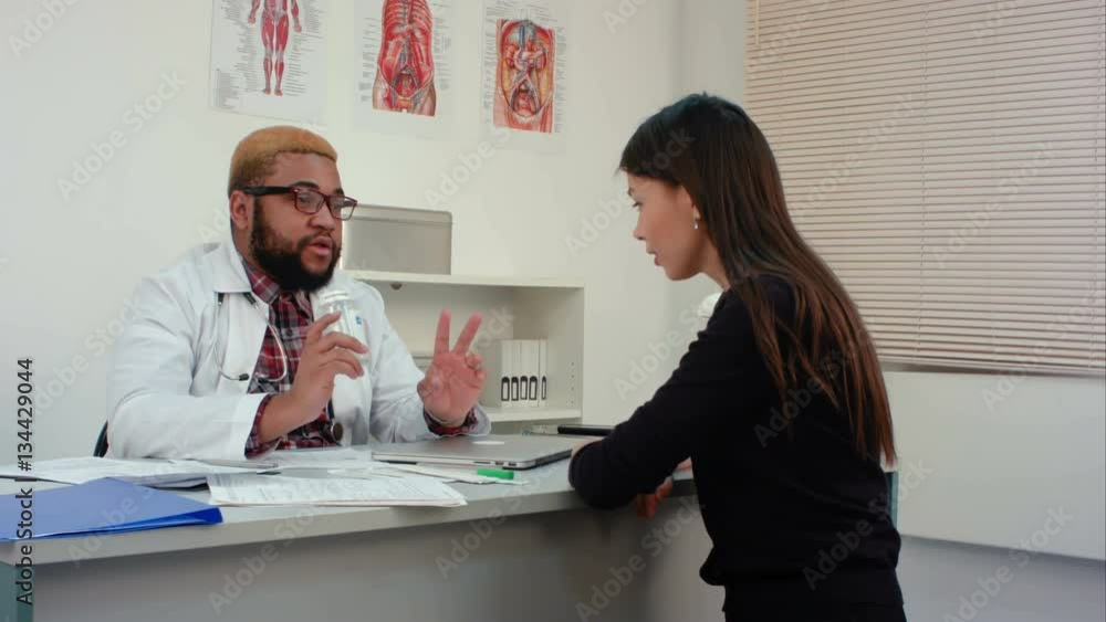 Doctor prescribing pills to female patient and explaining dosage Doctor prescribing pills to female patient and explaining dosage