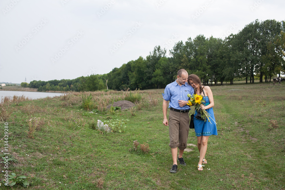 A young man and woman on a walk in the countryside near the river