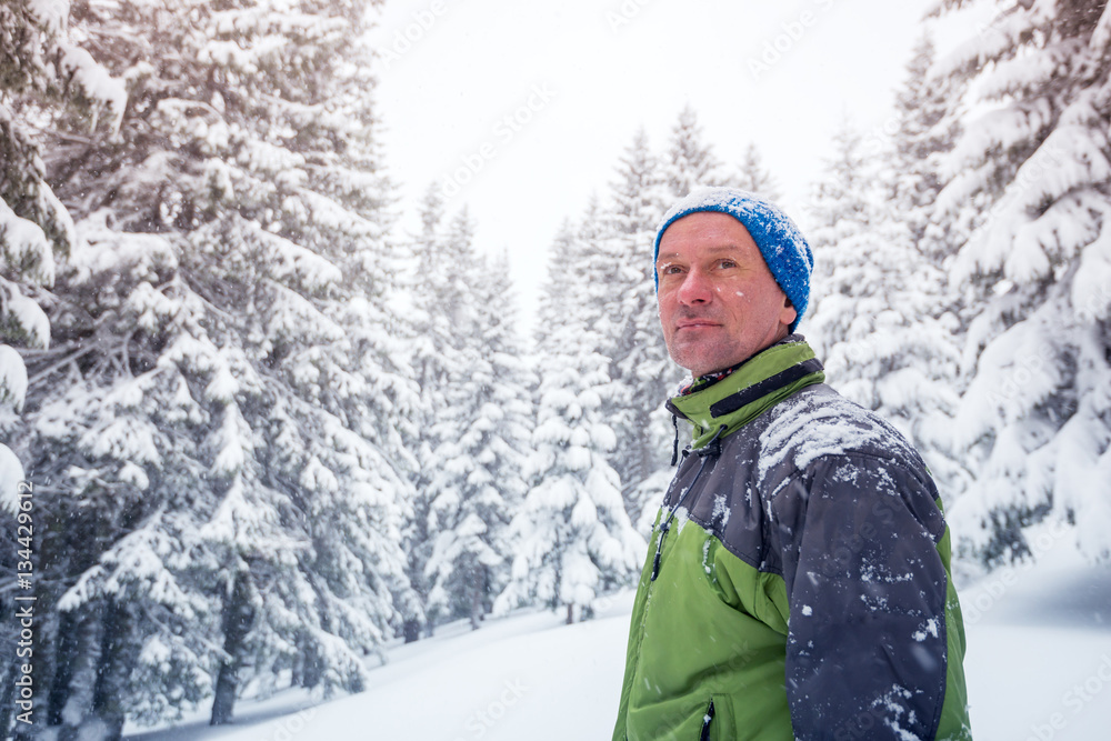 Portrait of happy man in the winter mountains