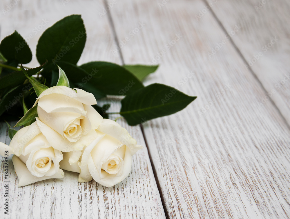 Obraz premium White roses on a wooden table