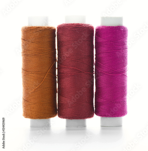 Colorful spools of thread on a white background