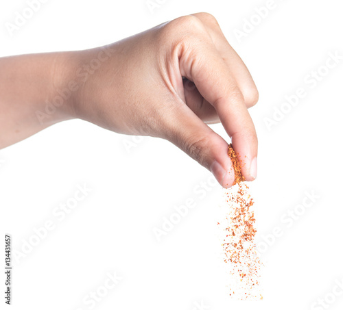 Hand sprinkling cayenne pepper,cayenne pepper on white  photo