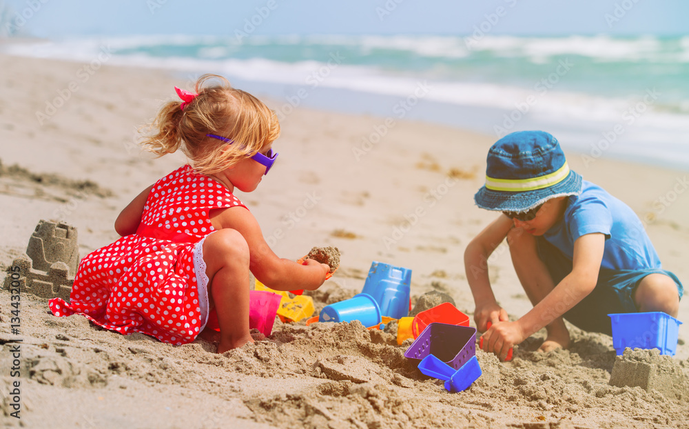 kids play with sand on summer beach kids play with sand on summer beach