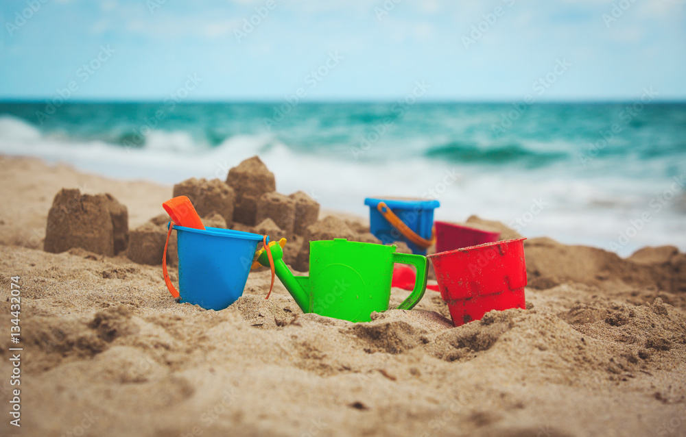 kids toys and sandcastle on beach kids toys and sandcastle on beach