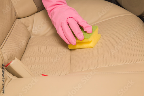 Car interior leather seats professionally chemical cleaning with sponge. Early spring cleaning or regular clean up.