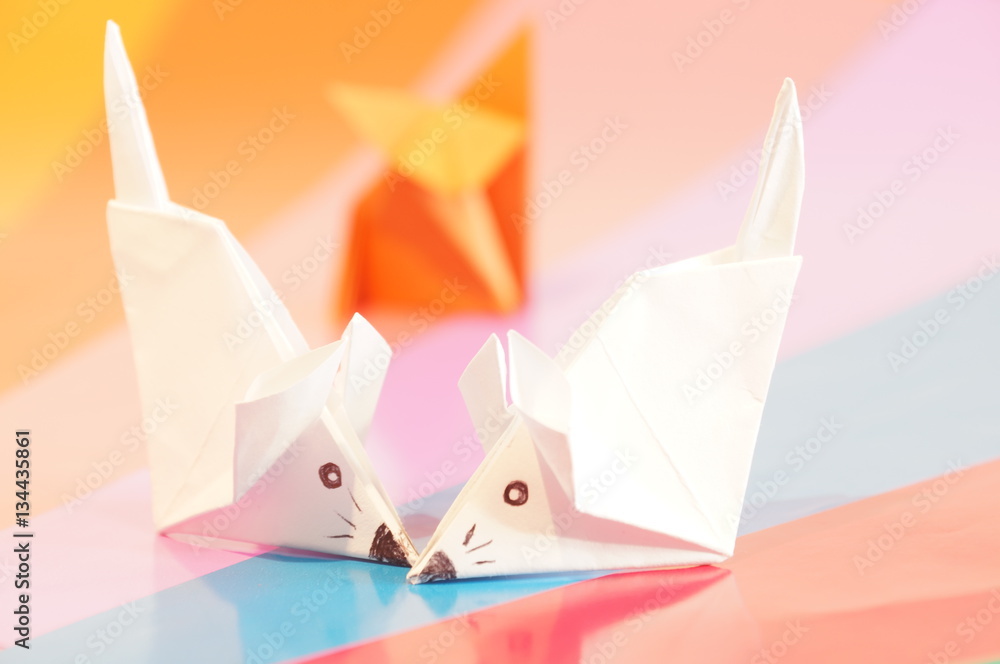 Paper origami fox and mouse are isolated on a colorful background Paper origami fox and mouse are isolated on a colorful background