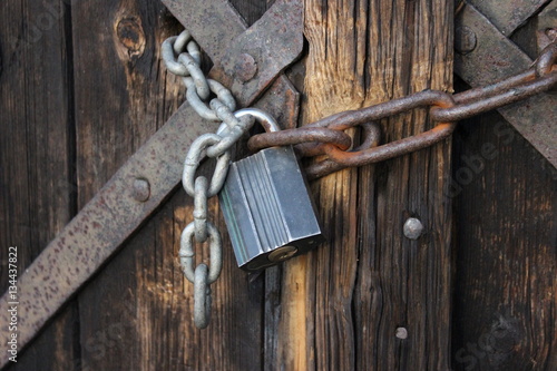 Old wooden doors chained with padlock photo