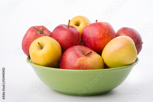 Group of apples in a green plate on white background