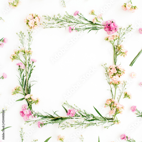 Wreath frame made of pink and beige wildflowers  green leaves  branches on white background. Flat lay  top view. Valentine s background