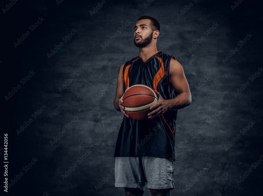 A black man holds a basket ball. A black man holds a basket ball.