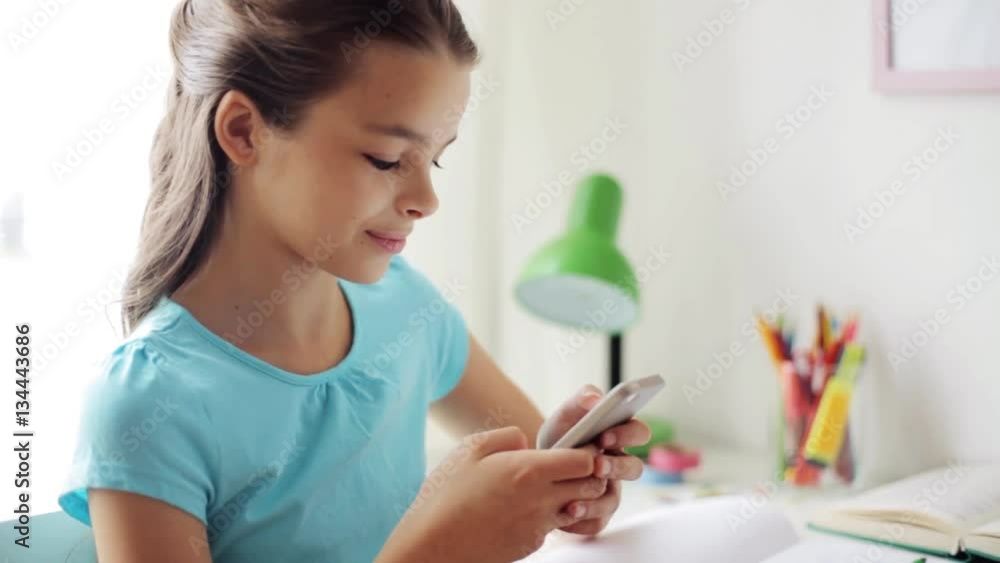 smiling girl texting on smartphone at home smiling girl texting on smartphone at home