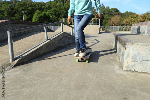 young skateboarder legs riding skateboard at skatepark © lzf