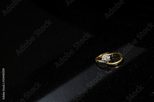 Wedding rings on a black marble stone table..