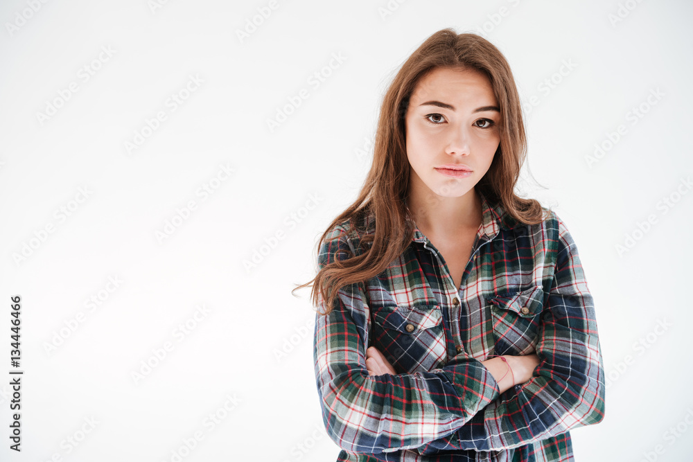 Sad upset young woman standing with arms crossed Sad upset young woman standing with arms crossed