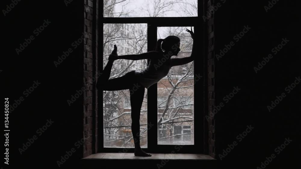Two young beautiful women doing yoga asana on window sill Two young beautiful women doing yoga asana on window sill