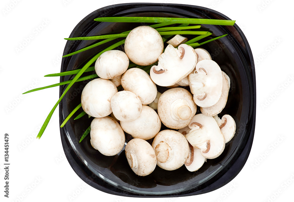 Whole and sliced mushrooms, green onion on black plate Whole and sliced mushrooms, green onion on black plate
