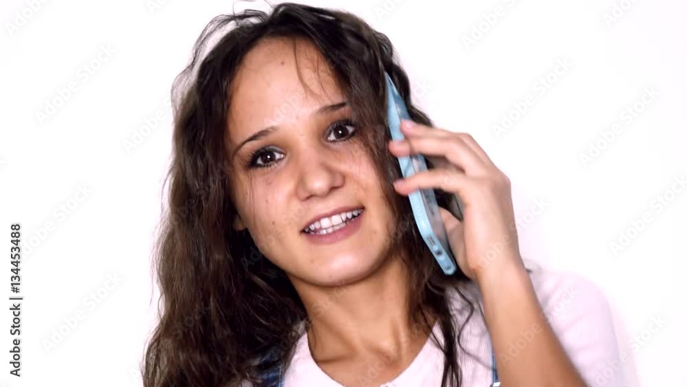 Young beautiful caucasian woman with curly hair talking mobile phone isolated on a white background. 3840x2160 Young beautiful caucasian woman with curly hair talking mobile phone isolated on a white background. 3840x2160