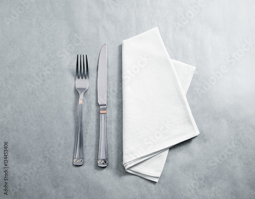 Blank white restaurant napkin mockup with knife and fork, isolated. Cutlery near clear textile towel mock up template. Cafe brand identity overlay surface for logo design. photo