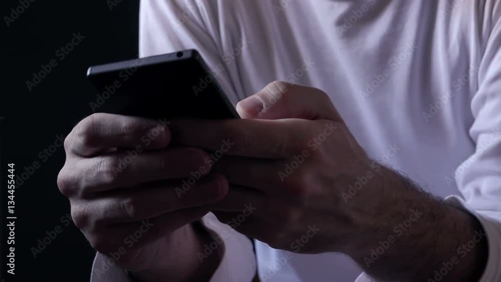 Casual man using smart phone, using thumbs to type SMS text message Casual man using smart phone, using thumbs to type SMS text message