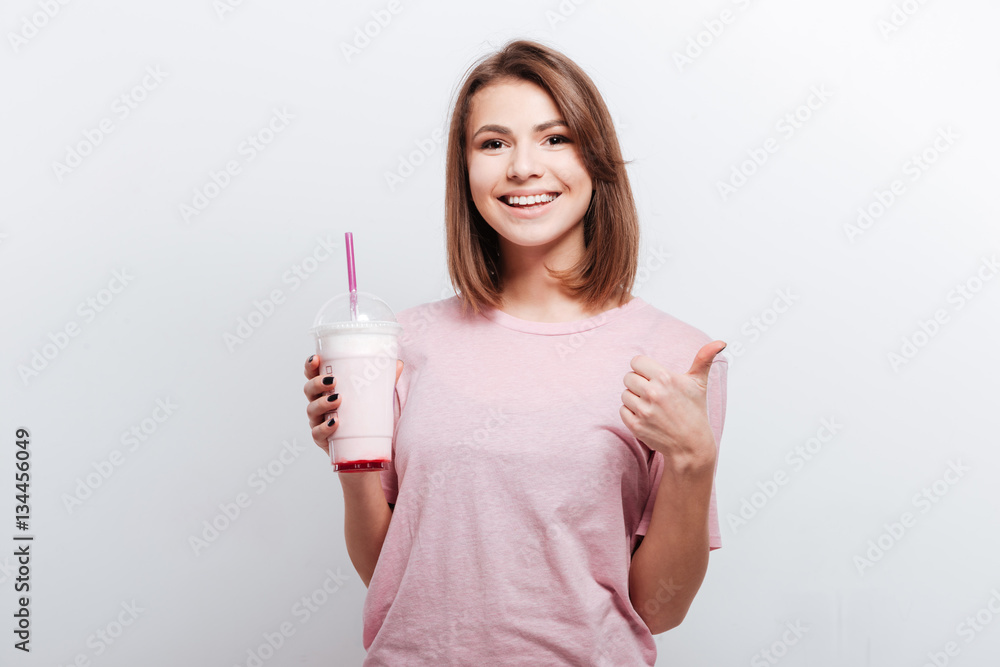 Pretty young lady holding cocktail and make thumbs up gesture Pretty young lady holding cocktail and make thumbs up gesture
