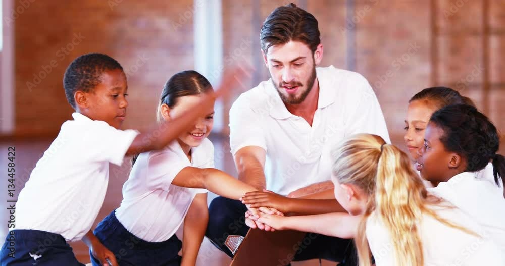 Sports teacher and school kids stacking hands in basketball court at school gym 4k Sports teacher and school kids stacking hands in basketball court at school gym 4k
