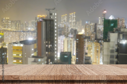 Empty wooden table over blur city night background