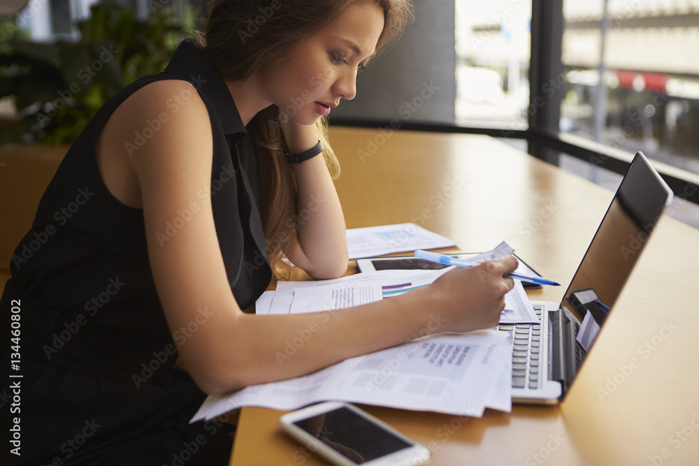 Businesswoman working in office, side view, close up Businesswoman working in office, side view, close up