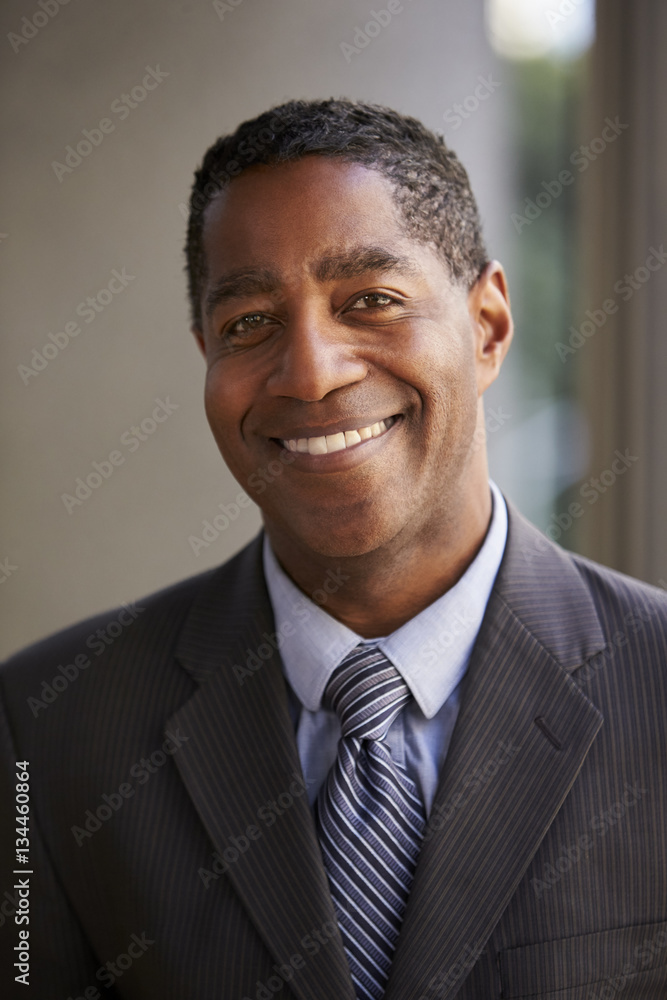 Middle aged black businessman smiling to camera, vertical Middle aged black businessman smiling to camera, vertical