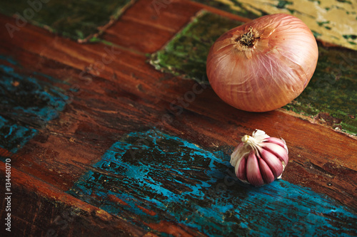 Quadro su tela Clove of whole white onion next to peeled wild garlic isolated on side of wooden