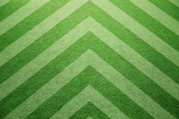 Artistic sunny artificial green soccer grass background with corner lines pattern.