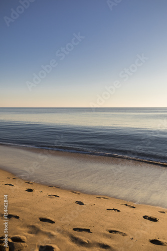 view on a beach at sunset with golden sand and quiet sea