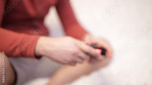 Blurring background. People with a controller in hands playing video game console.