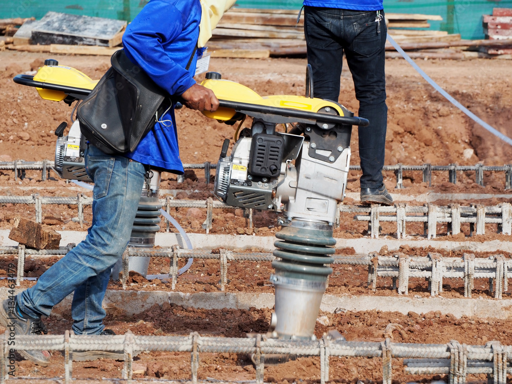 Φωτογραφία Construction worker compacting soil in house foundation using compactor