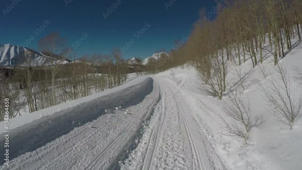Winter recreation snowmobile mountain peak trail POV. Snowmobile trail ride across high mountain meadow and forest at high speed high in central Utah in winter. Recreation and fun. Winter recreation snowmobile mountain peak trail POV. Snowmobile trail ride across high mountain meadow and forest at high speed high in central Utah in winter. Recreation and fun.