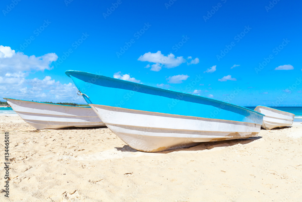 Blue white pleasure boats lay on sand