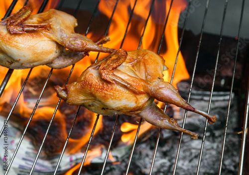 Grilling poultry quails in a restaurant