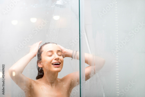 Young woman washing hair in the shower