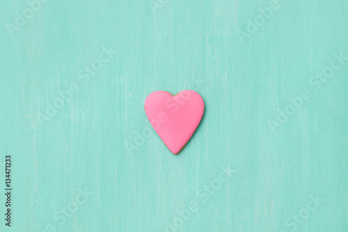 Top view on a little gingerbread cookie in shape of heart on light blue background. Flay layout. Love  Valentines s day concept