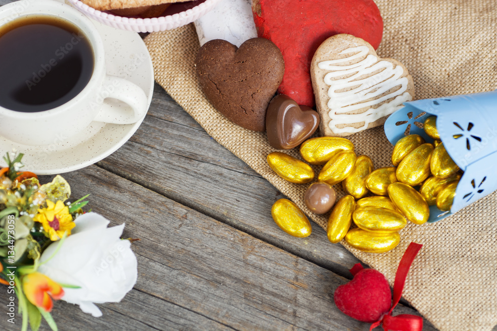 Heart shaped cookies (big and small as couple), cup of coffee, bouquet of flowers decoration. sunny morning. Romantic breakfast or Valentine's Day Breakfast. Toned image Heart shaped cookies (big and small as couple), cup of coffee, bouquet of flowers decoration. sunny morning. Romantic breakfast or Valentine's Day Breakfast. Toned image