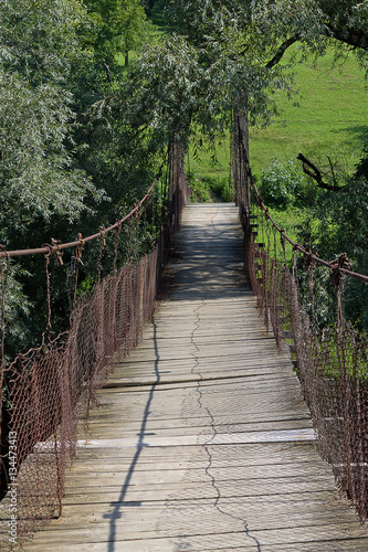 suspension bridge over the river in the green